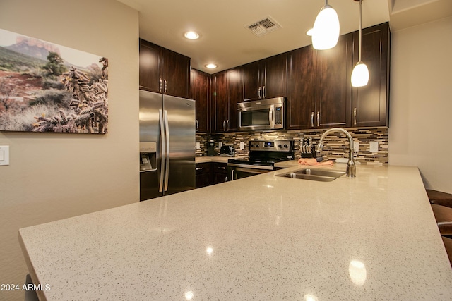 kitchen with a sink, light stone counters, visible vents, backsplash, and appliances with stainless steel finishes