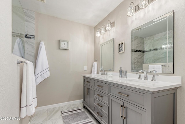 full bath featuring marble finish floor, a sink, baseboards, and double vanity