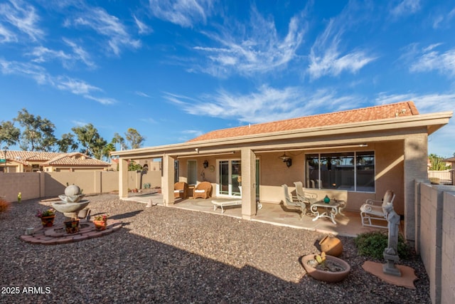 back of house with stucco siding, a fenced backyard, and a patio