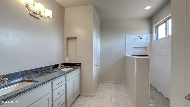 bathroom with tile patterned floors, vanity, and walk in shower