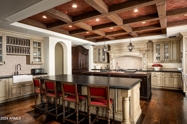 kitchen featuring beamed ceiling, a kitchen island, dark wood-type flooring, and coffered ceiling