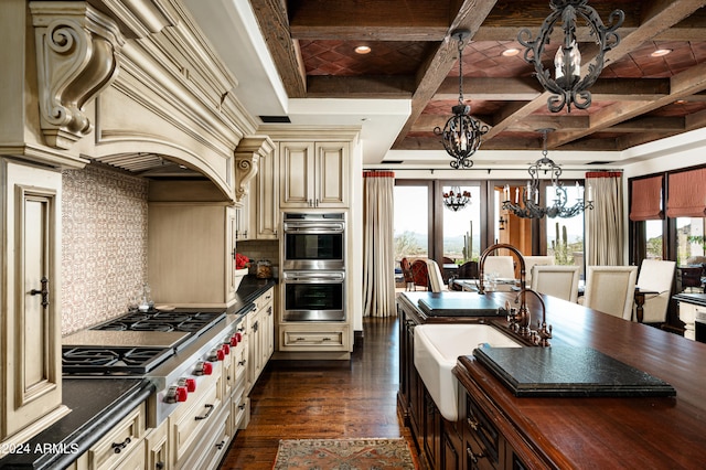 kitchen featuring cream cabinets, plenty of natural light, coffered ceiling, and appliances with stainless steel finishes