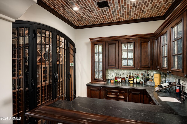 interior space featuring brick ceiling, tasteful backsplash, crown molding, and dark brown cabinets