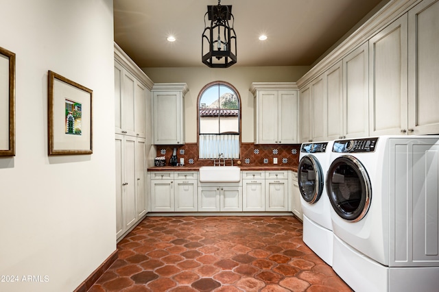 laundry room featuring cabinets, washer and clothes dryer, and sink