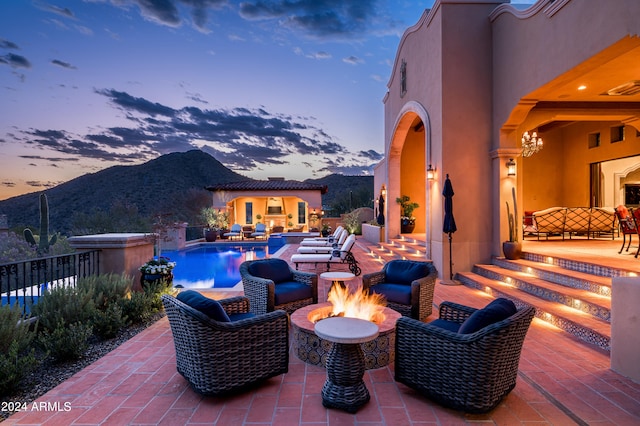 patio terrace at dusk with a fire pit and a mountain view