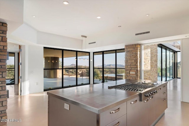 kitchen featuring a mountain view, gray cabinets, stainless steel gas stovetop, and a kitchen island