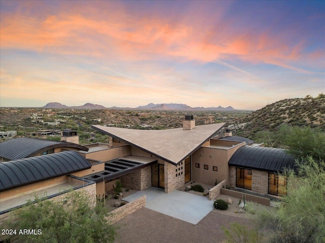 view of front of property featuring a mountain view and a patio area