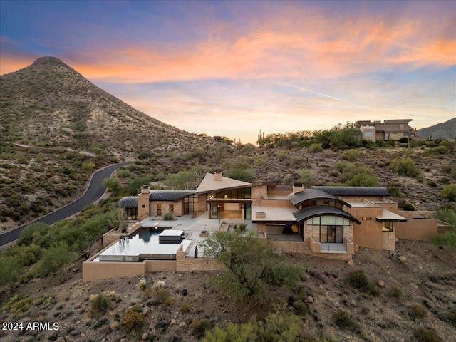 back house at dusk with a mountain view