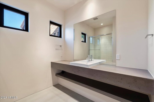 bathroom featuring vanity and a shower with door