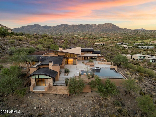 aerial view at dusk featuring a mountain view