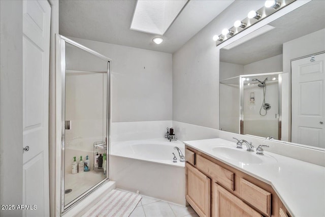 bathroom featuring independent shower and bath, a skylight, tile patterned flooring, and vanity