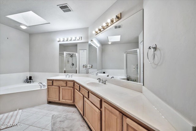 bathroom featuring vanity, a skylight, tile patterned floors, and shower with separate bathtub