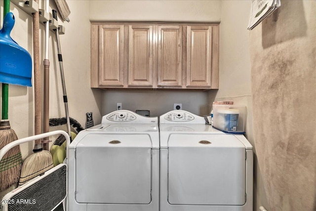 laundry room featuring washing machine and clothes dryer and cabinets