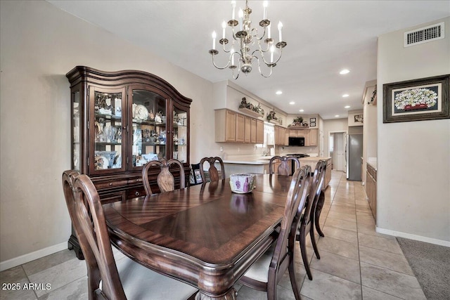 dining space featuring light tile patterned floors and a chandelier