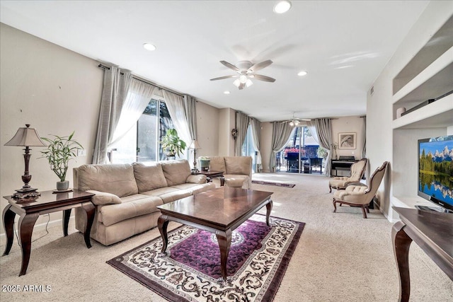 carpeted living room with ceiling fan and plenty of natural light