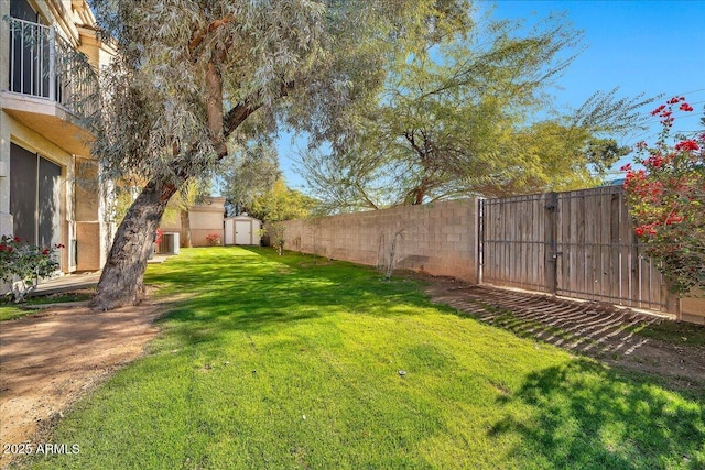 view of yard featuring central AC and a storage unit