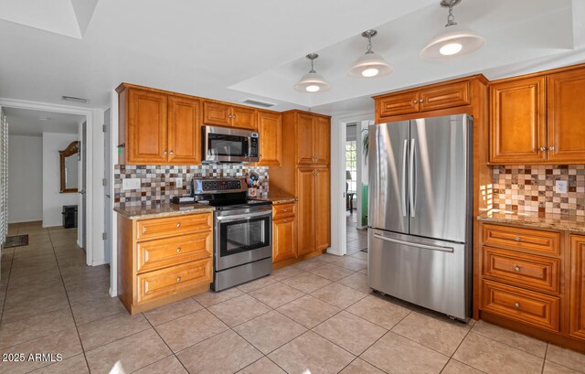 kitchen with light stone countertops, decorative light fixtures, backsplash, and stainless steel appliances