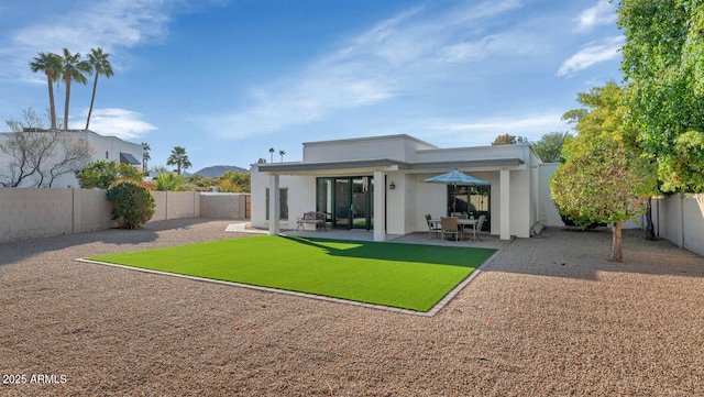 back of house with a lawn and a patio area