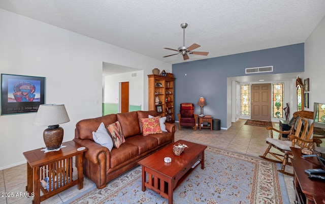 tiled living room with a textured ceiling and ceiling fan