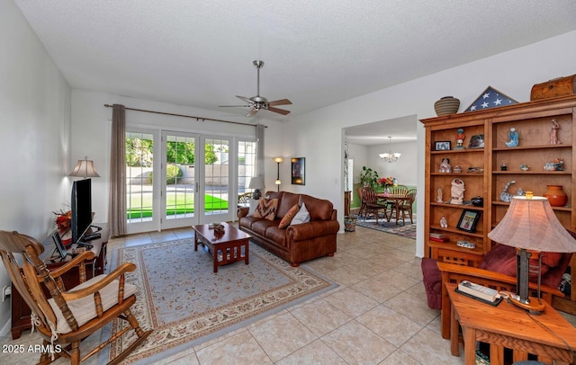 living room with ceiling fan with notable chandelier, light tile patterned floors, and a textured ceiling