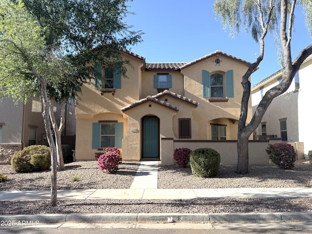 mediterranean / spanish-style home with stucco siding and a tiled roof