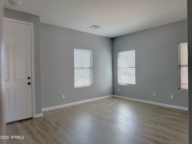 spare room with visible vents, baseboards, and light wood-style floors