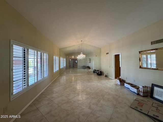 interior space featuring visible vents, baseboards, a chandelier, and lofted ceiling