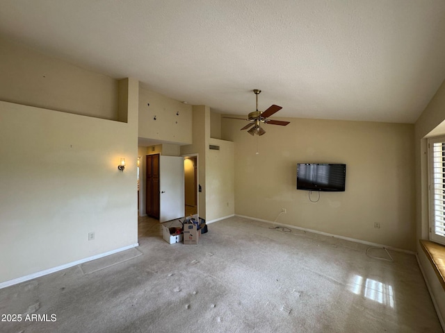 unfurnished living room with vaulted ceiling, baseboards, a ceiling fan, and a textured ceiling