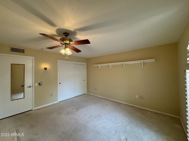 unfurnished bedroom featuring ceiling fan, visible vents, baseboards, a closet, and carpet flooring