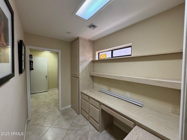 corridor featuring light tile patterned flooring, baseboards, and visible vents