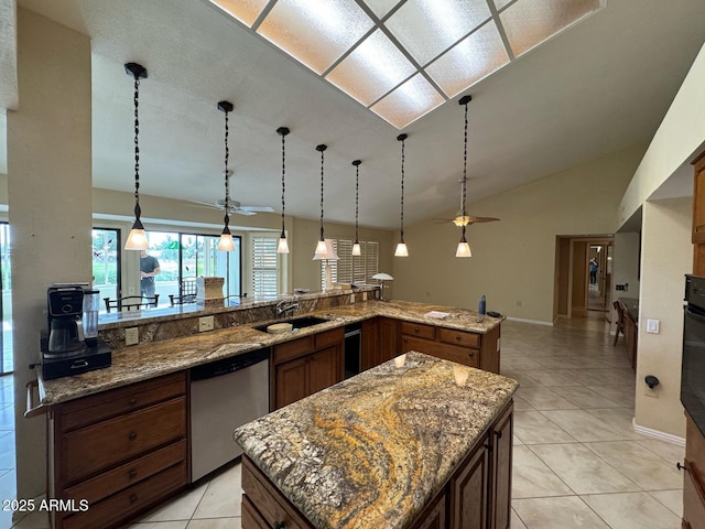 kitchen featuring a kitchen island, pendant lighting, dishwasher, a sink, and light tile patterned flooring