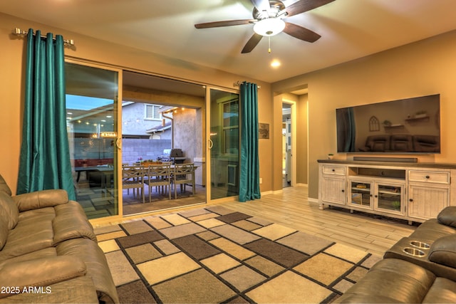 living room with light hardwood / wood-style floors and ceiling fan