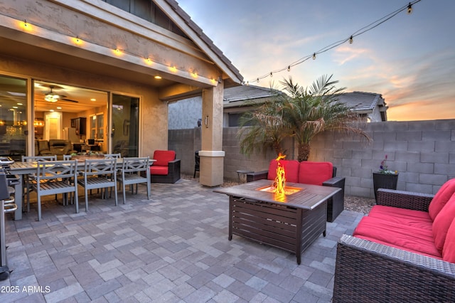 patio terrace at dusk featuring an outdoor living space with a fire pit