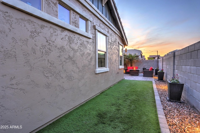 yard at dusk featuring a patio and an outdoor living space