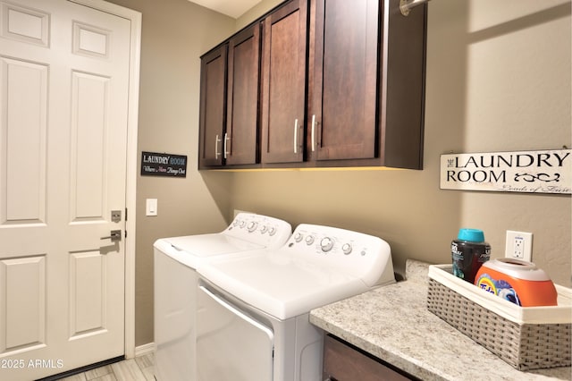 laundry room with washing machine and clothes dryer and cabinets