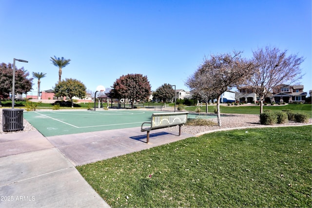 view of community with a yard and basketball hoop