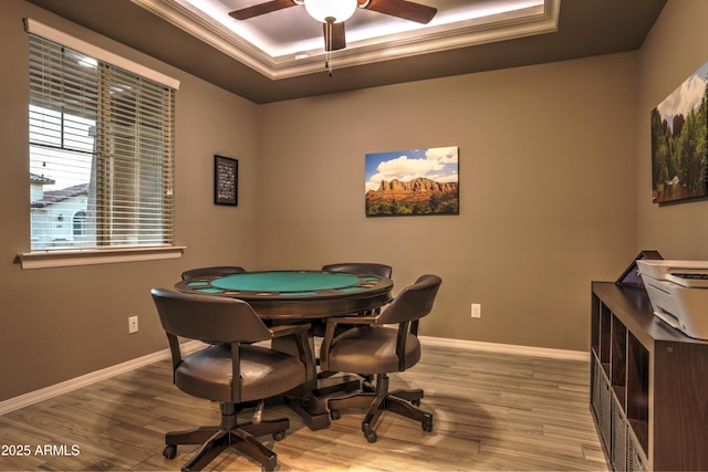 playroom with hardwood / wood-style floors, a raised ceiling, ceiling fan, and ornamental molding