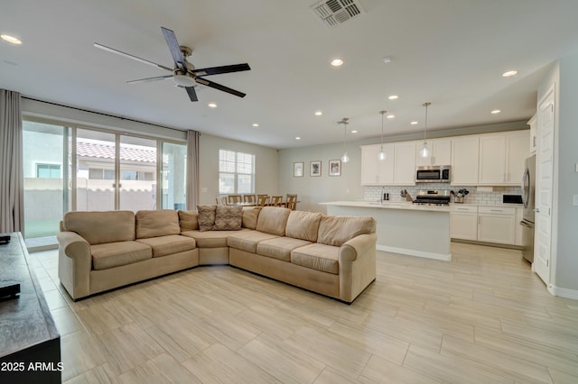 living room featuring visible vents, ceiling fan, and recessed lighting