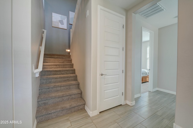 staircase with baseboards and visible vents