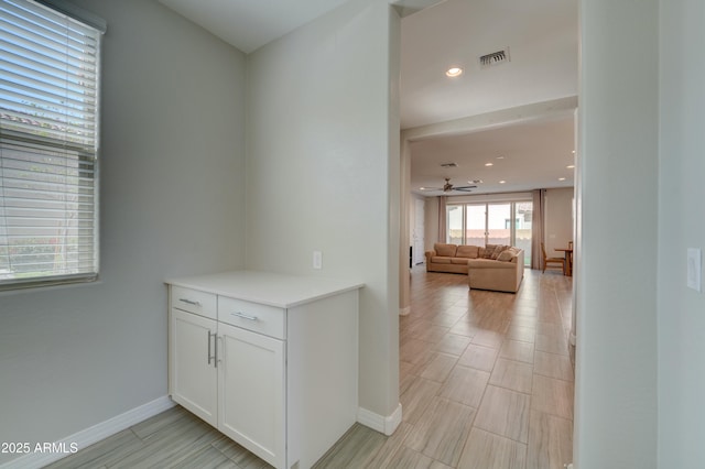 corridor with baseboards, visible vents, and recessed lighting