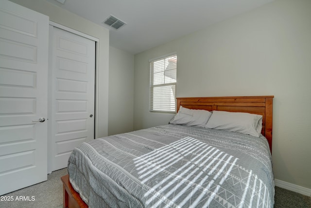 carpeted bedroom featuring visible vents, baseboards, and a closet