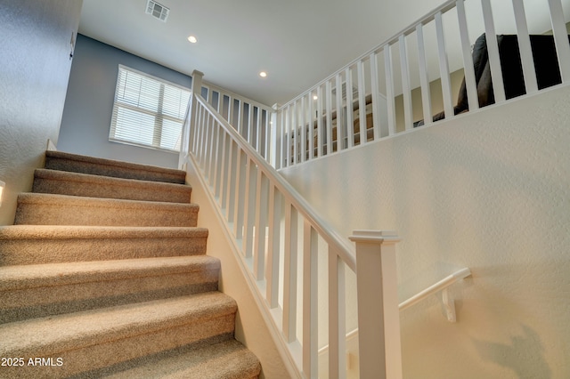 stairs with visible vents and recessed lighting
