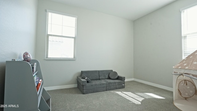 living area featuring carpet and baseboards
