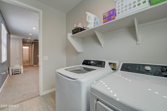 laundry area with washer and dryer, laundry area, light colored carpet, and baseboards