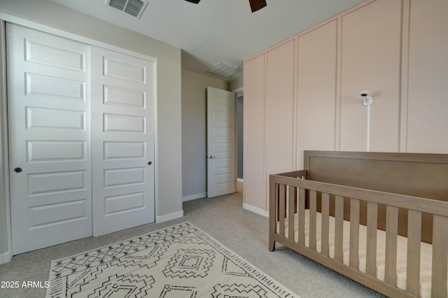 bedroom featuring baseboards, light carpet, a ceiling fan, visible vents, and a nursery area
