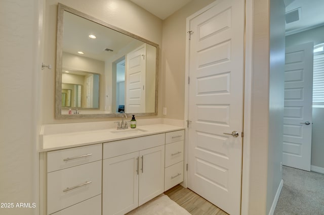 bathroom featuring visible vents, baseboards, recessed lighting, and vanity