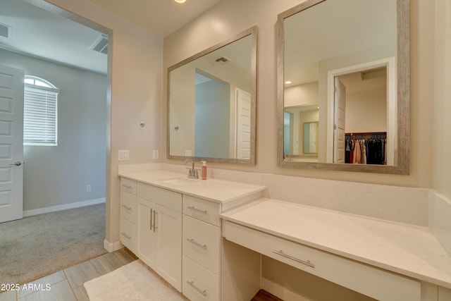 bathroom with vanity, baseboards, and visible vents
