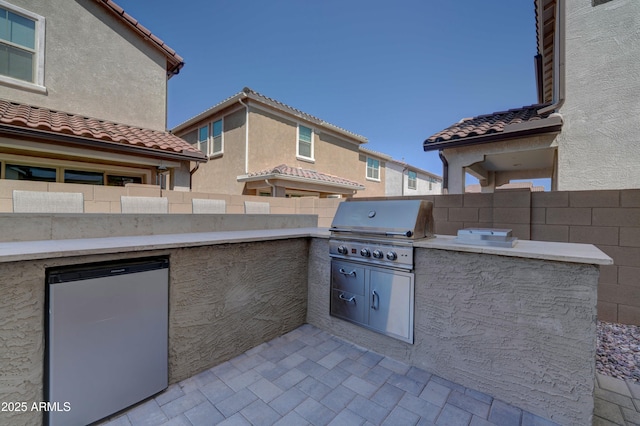 view of patio / terrace featuring area for grilling, an outdoor kitchen, and fence