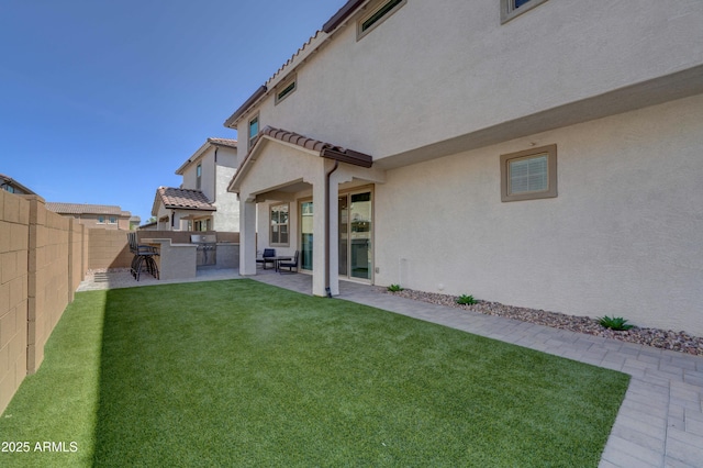 view of yard featuring a patio area, a fenced backyard, outdoor dry bar, and area for grilling
