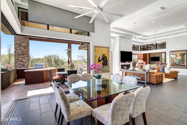 dining room featuring a towering ceiling and ceiling fan